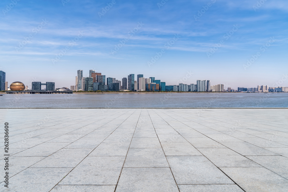 Empty square tiles and skyline of urban buildings..