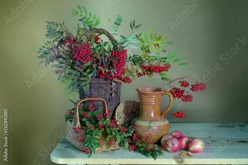 Still life with Rowan berries , viburnum , barberry and apples.Beautiful bouquet with red berries and apples .