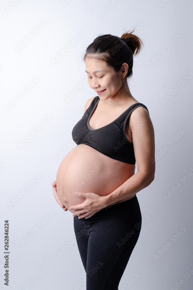 The side of the body of a pregnant woman wearing a black shirt With hands holding the belly on the White Blackground The side of the body of a pregnant woman wearing a black shirt With hands holding the belly on the White Blackground