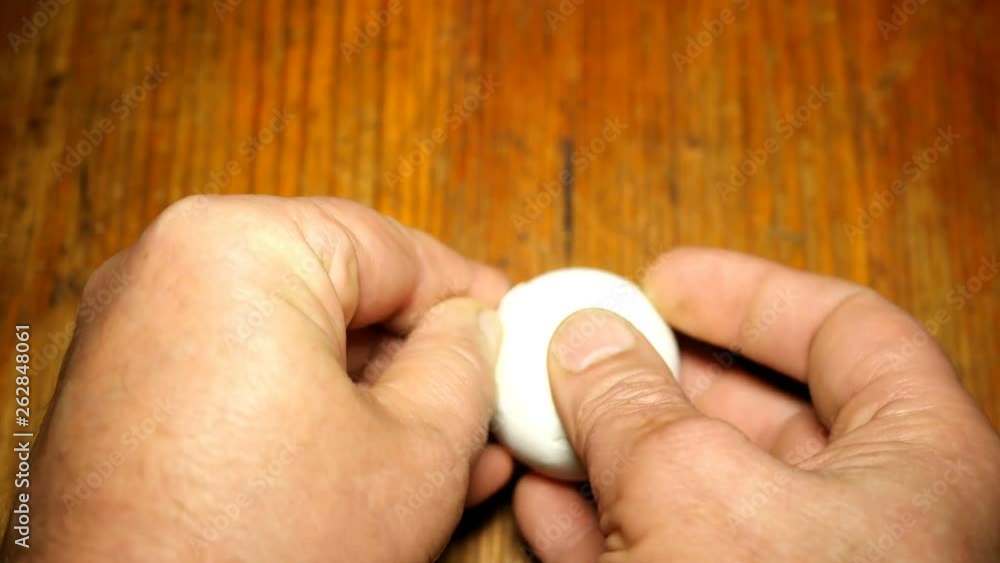 Human hands clean eggshell the boiled white chicken egg. Concept, easy cooking of eating. Close-up. Human hands clean eggshell the boiled white chicken egg. Concept, easy cooking of eating. Close-up.