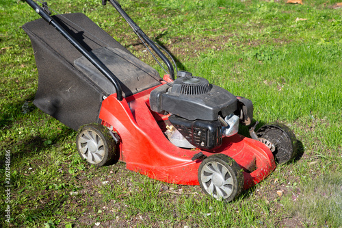 red lawn mower on green home garden