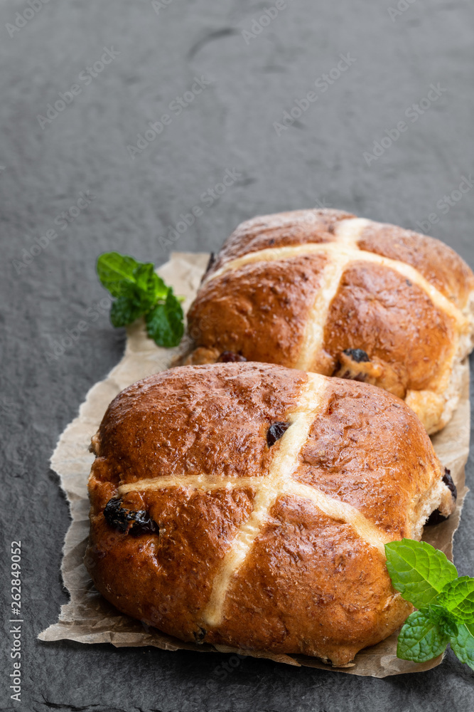 Easter cross buns and sultanas on black stone background Easter cross buns and sultanas on black stone background