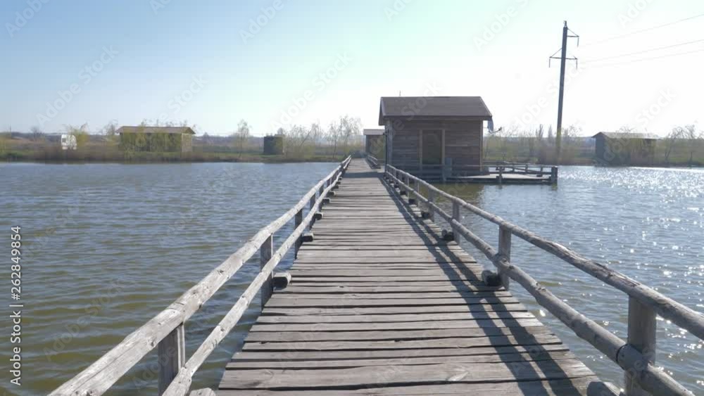 movement along the wooden pier to the house in the middle of the lake movement along the wooden pier to the house in the middle of the lake