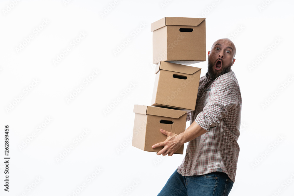 Young man carrying and dropping his stack of moving boxes - obrazy, fototapety, plakaty 