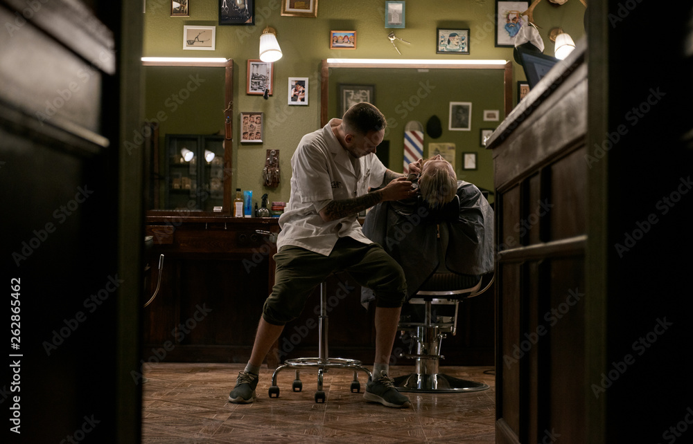 Man taking care of client in barbershop Man taking care of client in barbershop