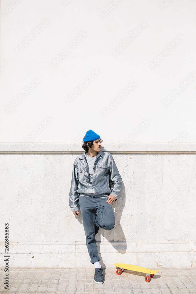 Confident stylish hipster with longboard Confident stylish hipster with longboard