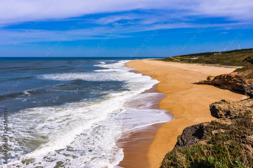 Foamy Atlantic ocean wave on deserted Nazare beach, Portugal.