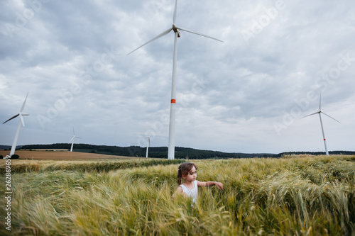 Little girl nder the wind turbine photo