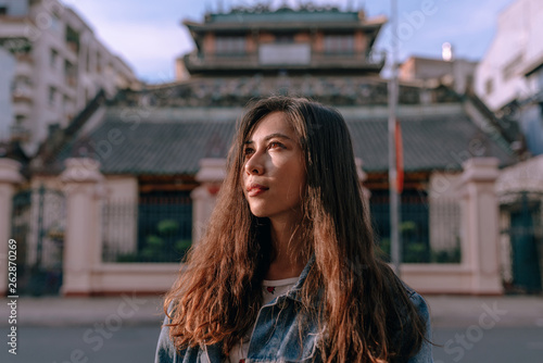 Portrait of young woman at coastal area during warm sunset photo