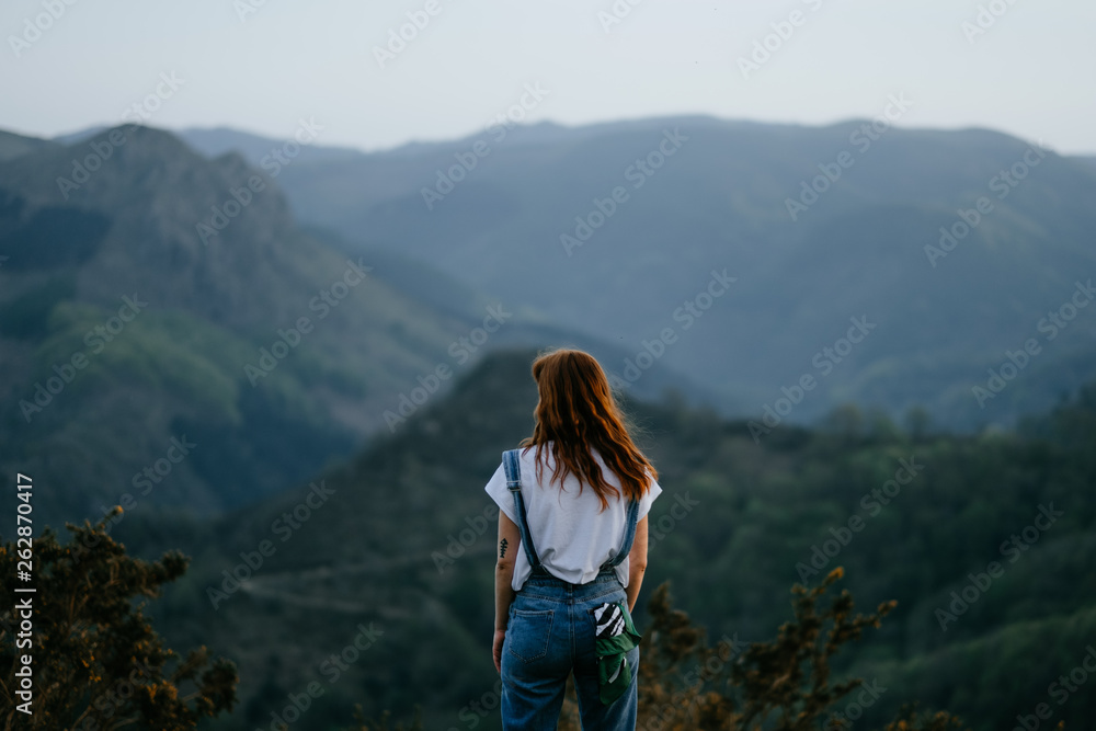 woman backwards looking to a stunning natural mountain landscape of the basque county woman backwards looking to a stunning natural mountain landscape of the basque county
