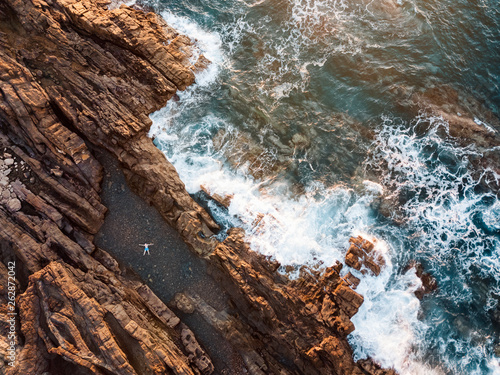 High angle view of a man relaxing in the natural swimming pool at the ocean's coastline
