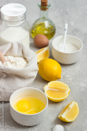 Ingredients for making cake - flour  eggs  milk or buttermilk  olive oil  sugar  lemon  baking powder. Food background. Bake sweet cake dessert concept. Copy space.