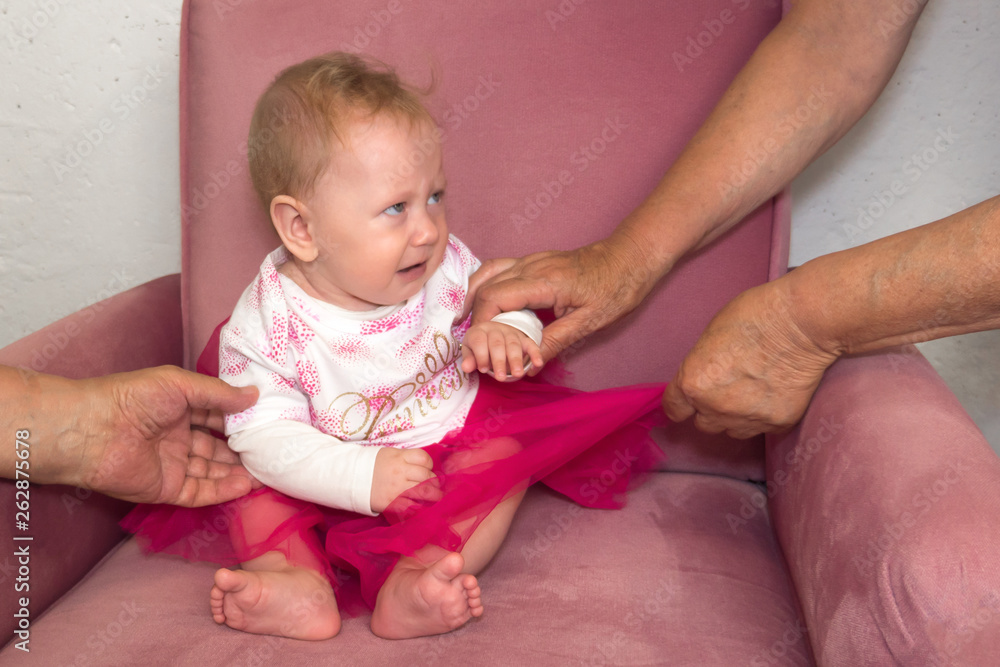 Irritated baby girl sitting in the arm chair. Little girl with negetive emotions. Irritated baby girl sitting in the arm chair. Little girl with negetive emotions.