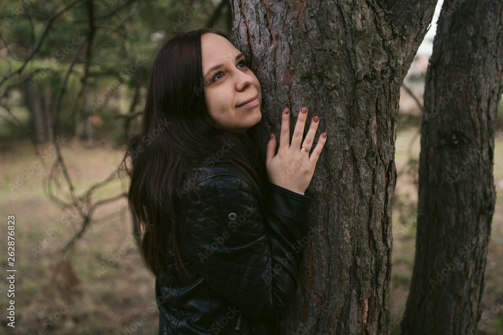 Young woman hugging tree in the forest. Smiling young woman nature lover relax on summer day hug a tree enjoy in beautiful day Young woman hugging tree in the forest. Smiling young woman nature lover relax on summer day hug a tree enjoy in beautiful day