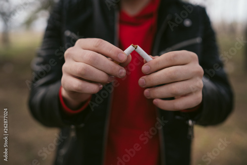 Crop men breaking cigarette and quitting smoking. Closeup of crop man splitting cigarette for idea of stop smoking 
