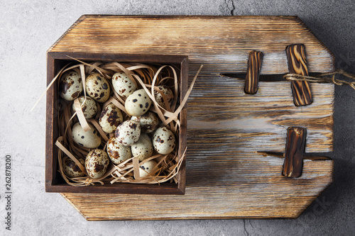 Quail eggs. Flat lay composition with small quail eggs on the natural wooden background. One broken egg with a bright yolk. photo