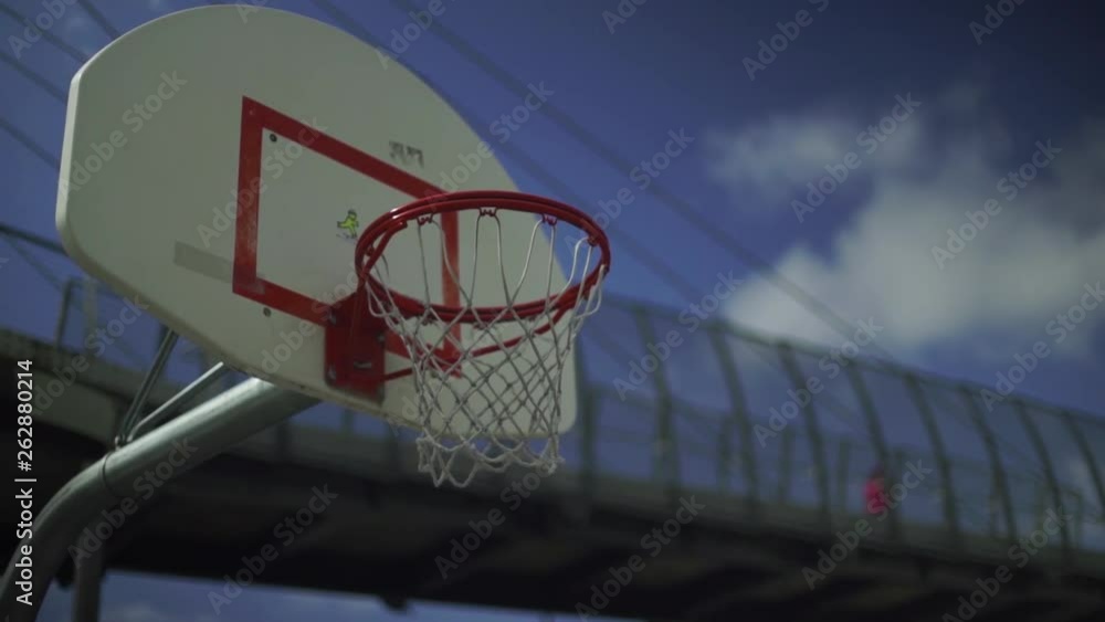 Low Angle Shot of Basketball Hoop on Outdoor City Court Against a Bright Blue Sky Low Angle Shot of Basketball Hoop on Outdoor City Court Against a Bright Blue Sky