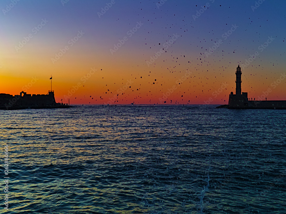 Sunset at the port of Chania, in Crete island Greece.  Vivid vibrant orange, blue, yellow, purple colors at dusk time.