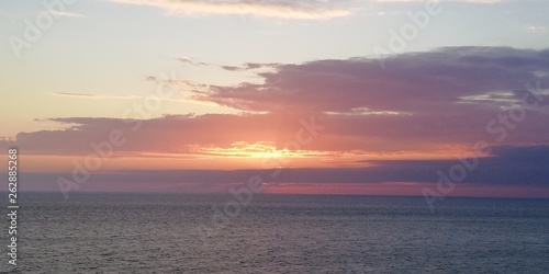 Fantastic seascape. The setting sun painted the sky and the sea in blue  pink and lilac tones. The solar path shines on the sea surface