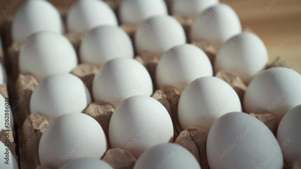 Lots of eggs in a cardboard box on the table. Lots of eggs in a cardboard box on the table.