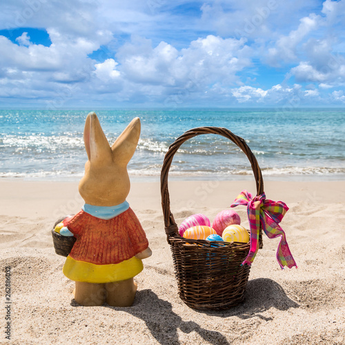 Beach Easter background with bunny and color eggs