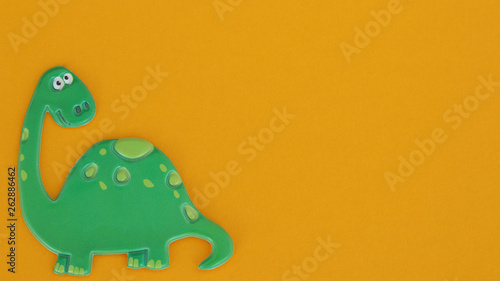 Fotografie green dinosaur on an orange background