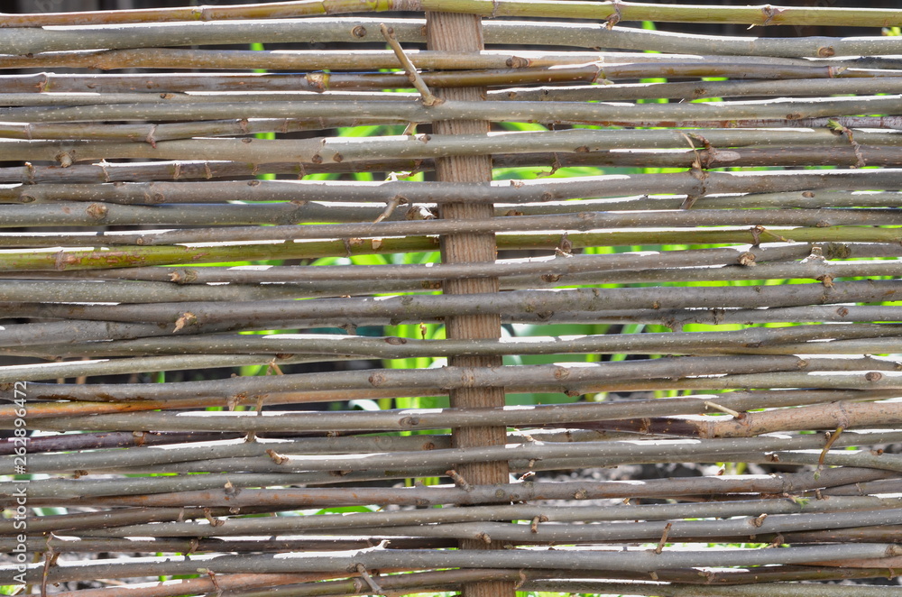 The natural fence is woven from flexible rods. The natural fence is woven from flexible rods.