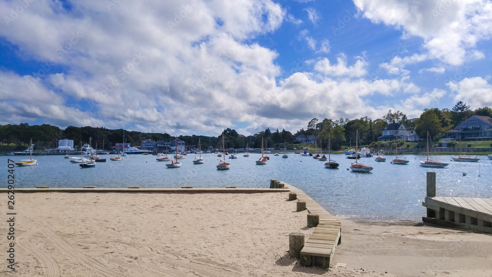 Moored boats at a marina on a sunny summer day, beneath a beautiful blue sky