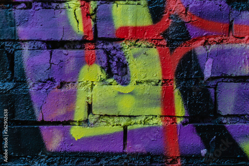 Old colorful paint with cracks on red brick wall as background, texture