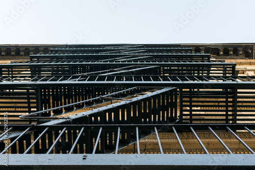 Old-fashioned cast-iron fire escape on the outside of an apartment building in New York City's Harlem neighborhood, NYC, Manhattan, USA