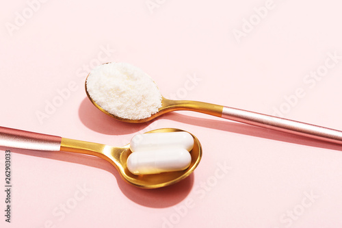 Fotografie Collagen powder and pills on pink background