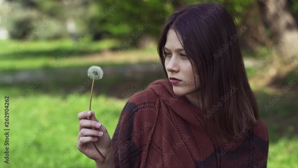 Beautiful young Woman Blowing a dandelion outdoors in the Park, Slow motion clip Beautiful young Woman Blowing a dandelion outdoors in the Park, Slow motion clip