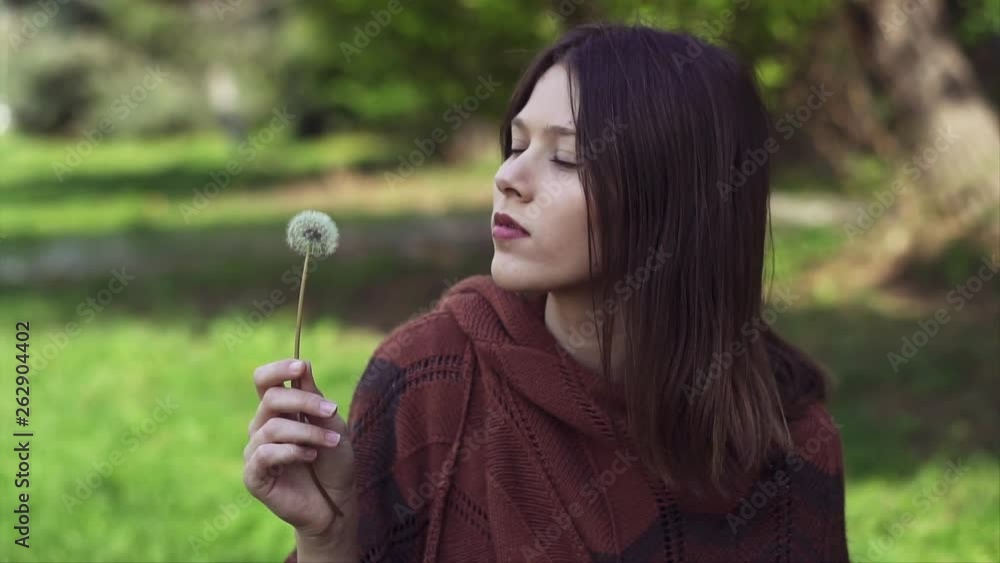 Beautiful young Woman Blowing a dandelion outdoors in the Park, Slow motion clip Beautiful young Woman Blowing a dandelion outdoors in the Park, Slow motion clip