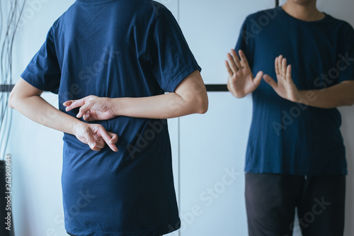 Lie asian woman with hand crossing fingers behind back telling liar and cheating,April Fools' Day concept
