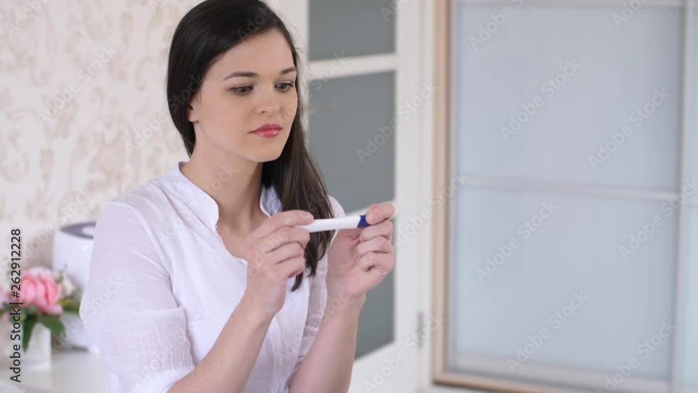 Surprised woman with pregnancy test at the room Surprised woman with pregnancy test at the room