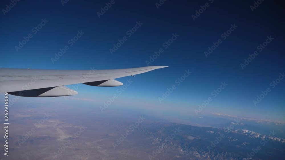 Airplane flight. Wing of an airplane flying above the clouds with sunset sky. View from the window of the plane. Aircraft. Traveling by air. Airplane flight. Wing of an airplane flying above the clouds with sunset sky. View from the window of the plane. Aircraft. Traveling by air.