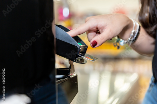 Woman hand using payment terminal in shop. Paying with credit or debit card, credit card reader. Finance and banking concept. Buy & Sell service and product.