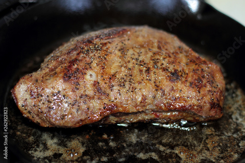 Tri-tip roast in a cast iron pan resting on the oven.