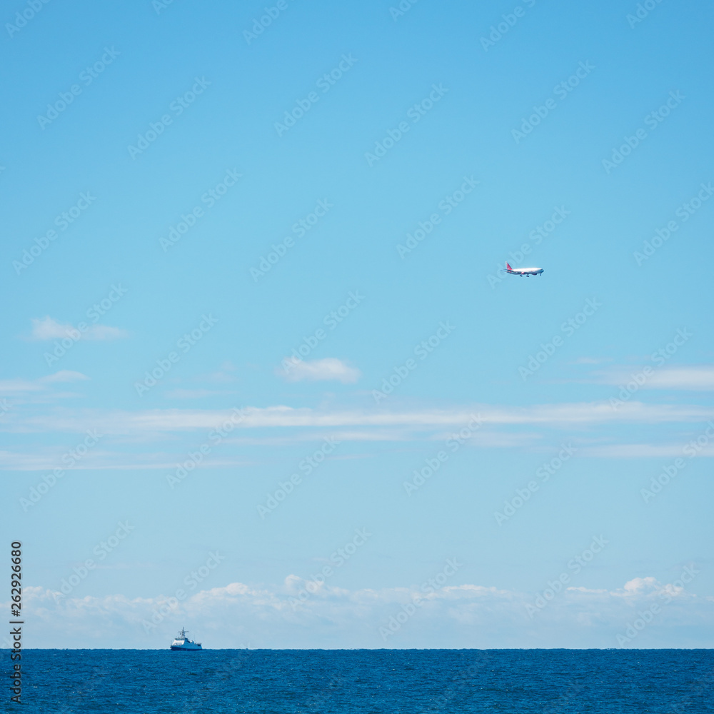 Sea horizon and clear blue sky. Ship and plane on the horizon. Sea horizon and clear blue sky. Ship and plane on the horizon.