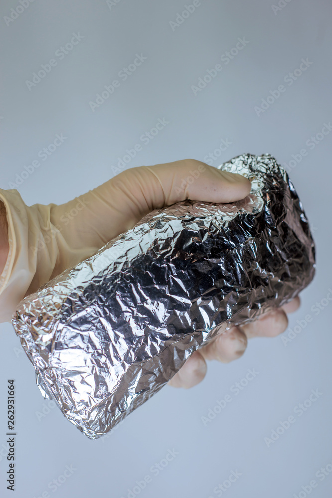 Fototapeta premium medical officer of the laboratory holds in his hand confiscated by the police a package of powder of narcotic substance, for the analysis