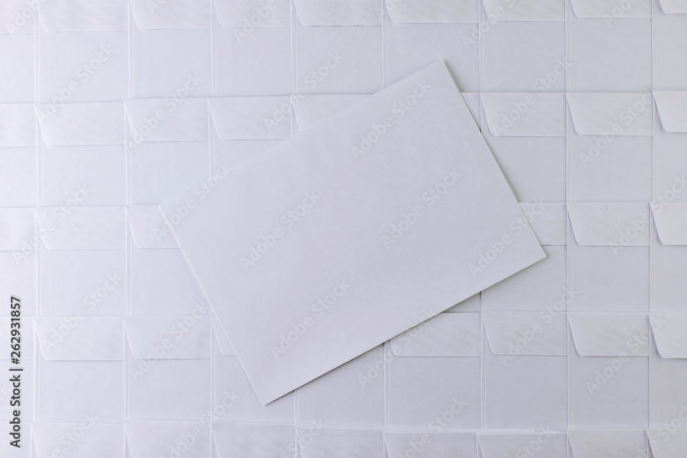 set of empty white envelopes lying in a row on a desk in the office, one envelope removed from the row and lying on the surface, short focus, toning set of empty white envelopes lying in a row on a desk in the office, one envelope removed from the row and lying on the surface, short focus, toning