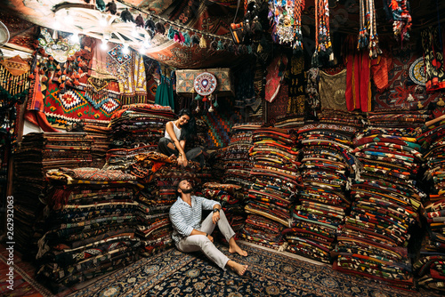 Couple having fun. Couple in love in Turkey. Man and woman in the Eastern country. Gift shop. A couple in love travels. Persian shop. Tourists in store. Oriental carpet. Cappadocia. Morocco