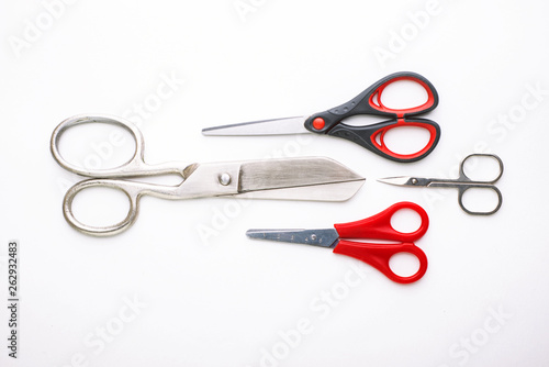 scissors for different purposes and sizes on a white background, vintage and new, plastic and metal photo