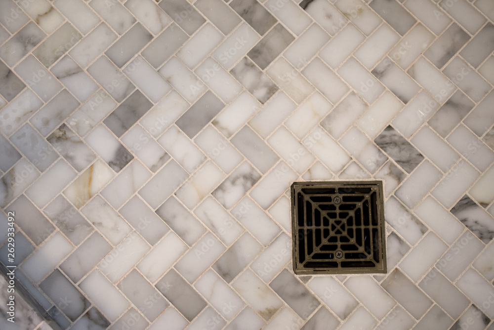 Bathroom floor drain with white marble herringbone tile