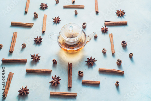 Creative tea arrangement with cinnamon, anise stars, teapot and tea bowls on a white background with copy space. Hot drink creative header.