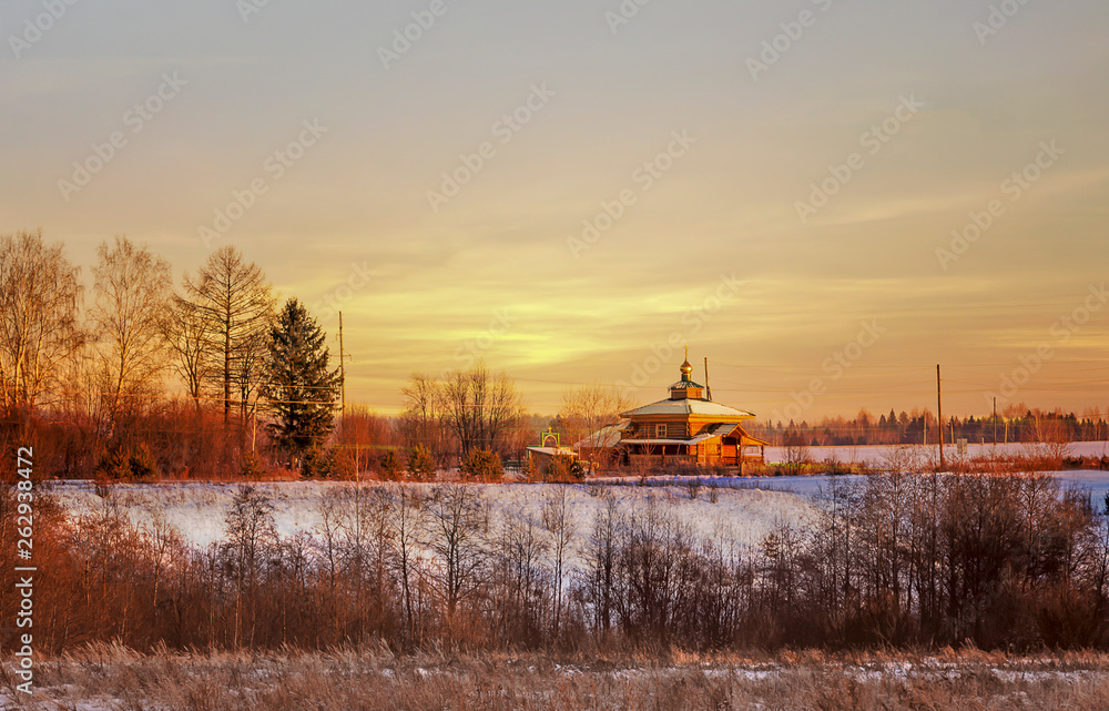 Obraz premium Bright sunset is yellow - the sun, red with a lilac shade, in the remote village in a midland of Russia.