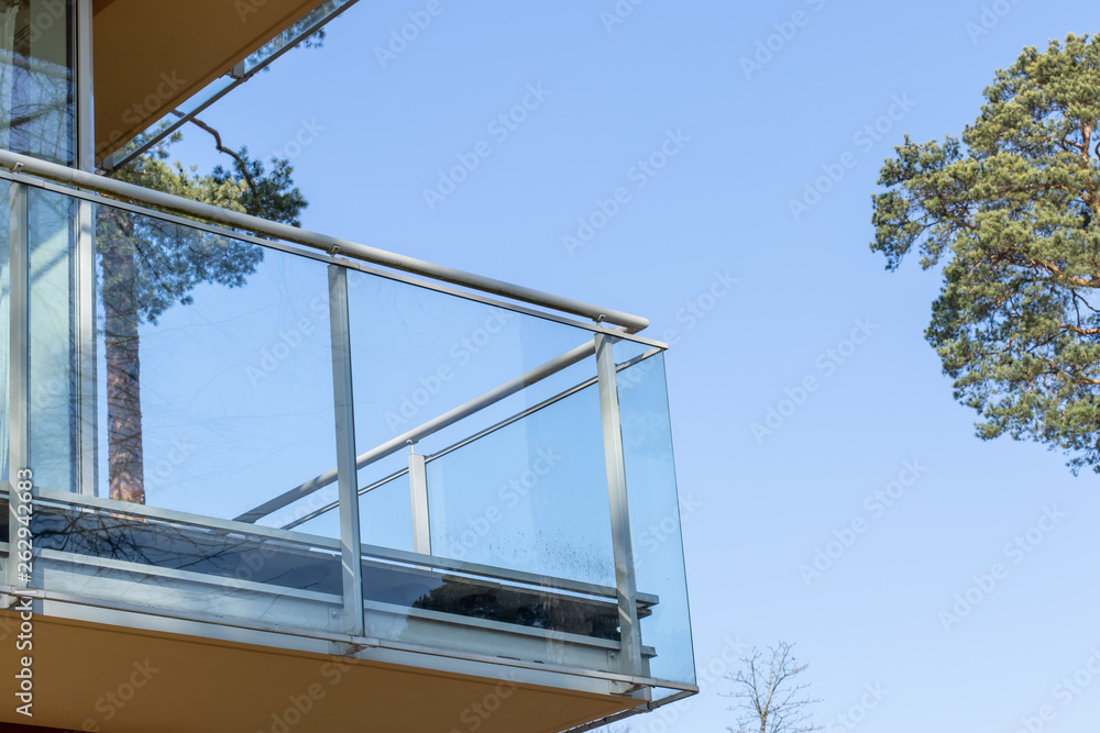 Furnished balcony of the house in the forest on the background of blue sky Furnished balcony of the house in the forest on the background of blue sky