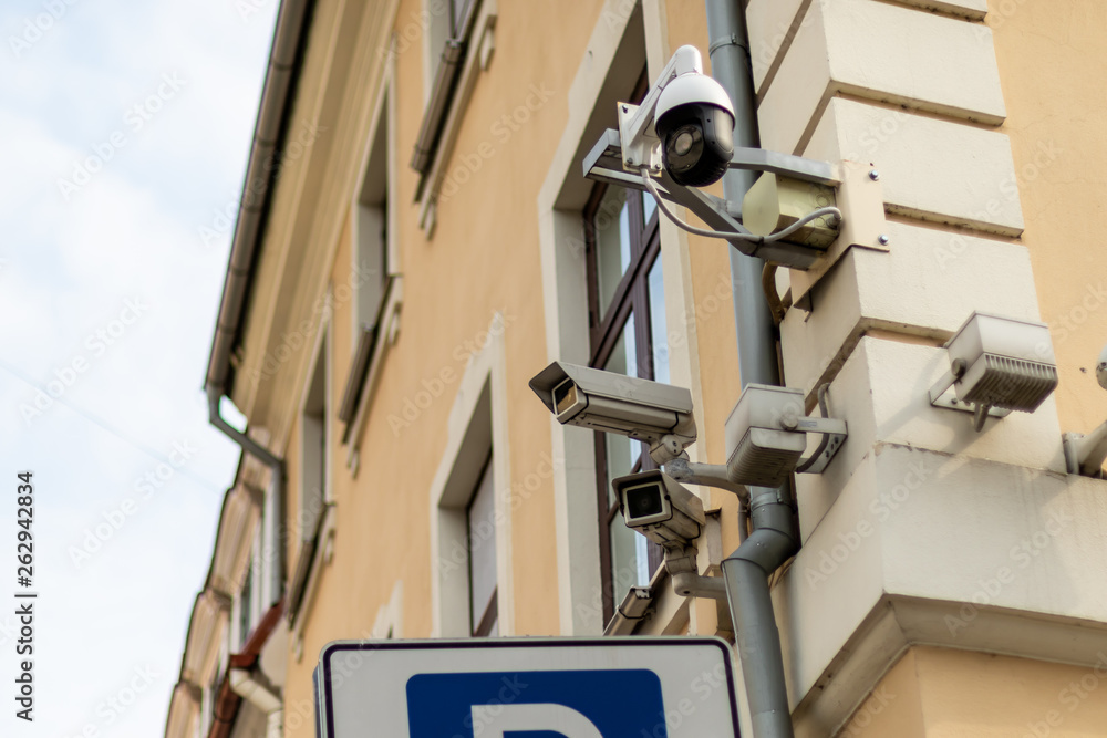 Three Security cameras frontal view on building wall Three Security cameras frontal view on building wall