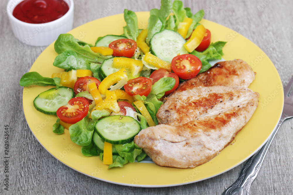 Grilled chicken breast with raw vegetables salad