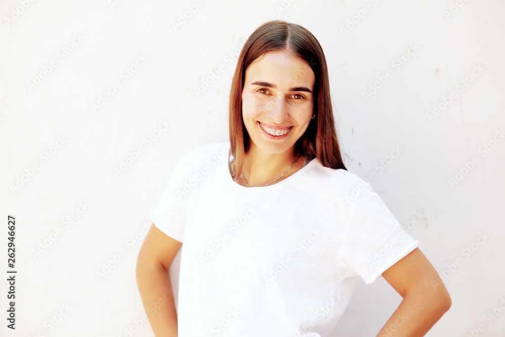 Beautiful girl smiling looking on a camera, white teeth with braces. Dental care. Beauty woman smile with orthodontic accessories. Cosmetic dentistry, orthodontics treatment. Beautiful girl smiling looking on a camera, white teeth with braces. Dental care. Beauty woman smile with orthodontic accessories. Cosmetic dentistry, orthodontics treatment.